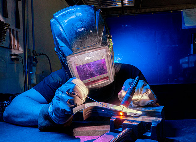 Person wearing a helmet welding a part