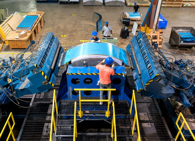 Overhead view of people operating L-1500 stretch forming machine